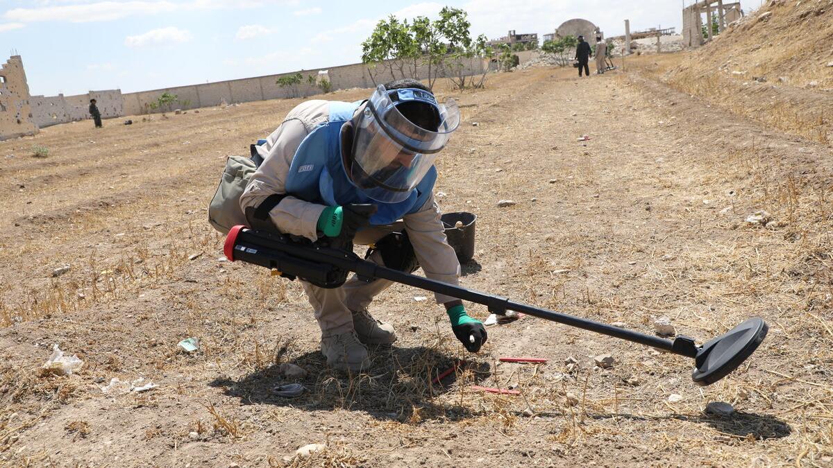 deminer working in demining suit