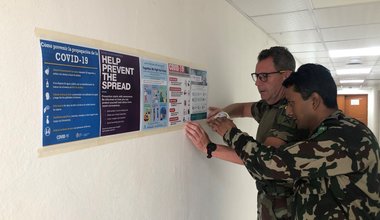 Comdt N Buckley SSO Media and Maj Sanjeev SO PR displaying COVID 19 Awareness posters in UNDOF HQ