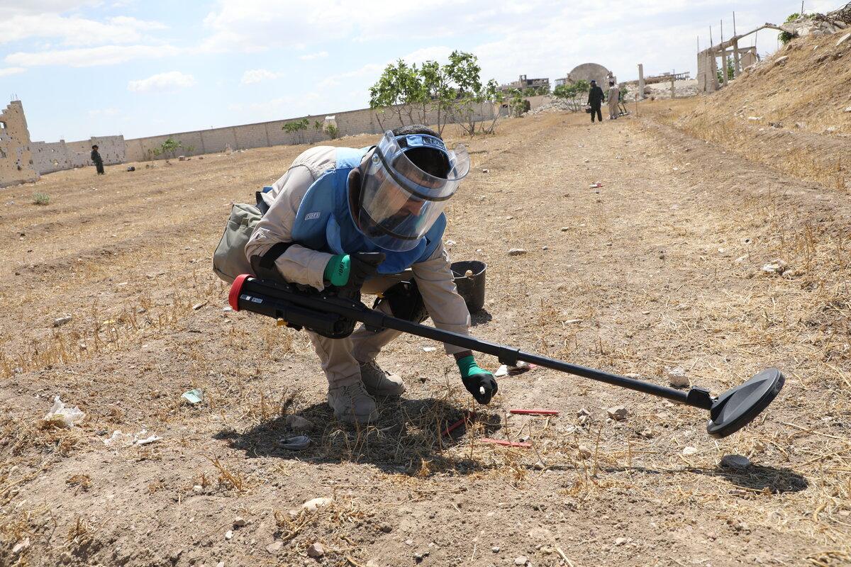 deminer working in demining suit