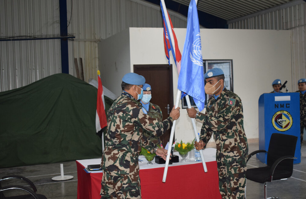 NMC Commanders exchange the UN Flag to complete the transfer of authority